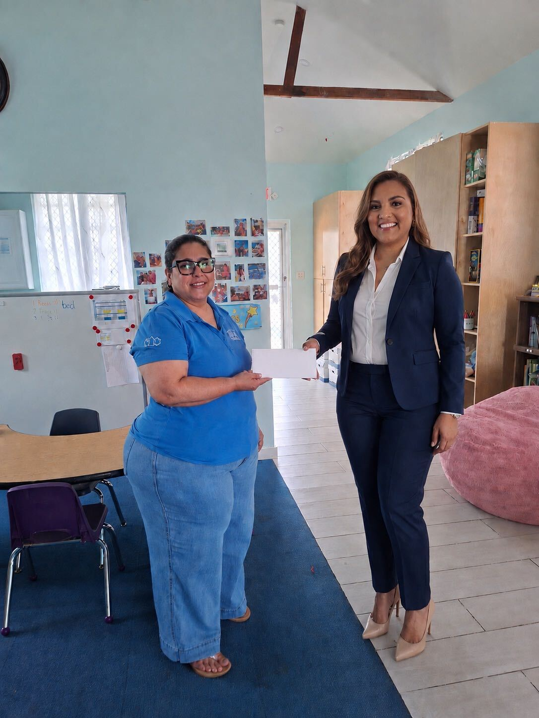 Two women presenting an envelope in support of Riley’s surgery.